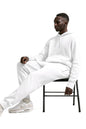 Ensemble survêtement homme Blanc STYCLOV avec veste et pantalon assortis assis sur une chaise au style streetwear premium et confortable.
