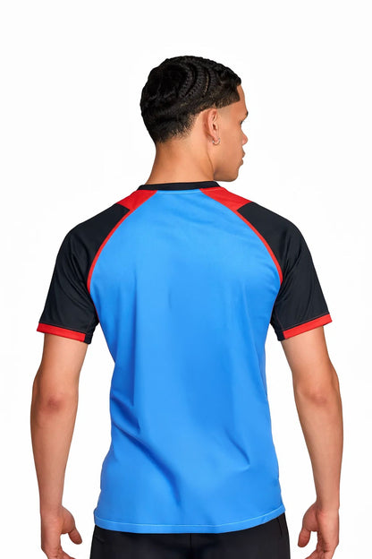Homme portant le maillot de football PIM Royale Bleu à motifs graphiques, vue de dos.